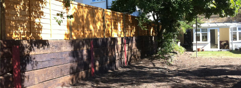 A sleeper retaining wall and new fence along a garden path